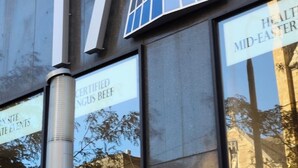 En byggnad med en stor logotyp i form av ett "T", en glasfasad och skyltar som visar att det är platsen för evenemangen "Certified Angus Beef" och "Healthy Mid-Easterner".