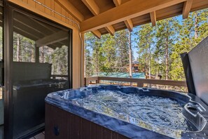 A hot tub on a wooden deck with a glass door and a view of trees and a building. - Serene Luxury Stay Near Keystone Gondola (Keystone)