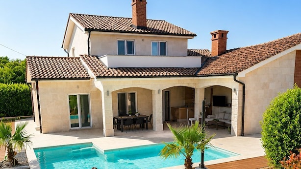 A two-story house with a swimming pool, outdoor seating, and a covered patio area. - Vacation home away from the hustle and bustle (Sveti Ivan Dobrinjski)