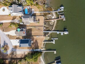 An aerial view of a property with a swimming pool, dock, and a large building with a flat roof. - Heaven's Waterfront Retreat | Located in Sneads Ferry (Sneads Ferry)