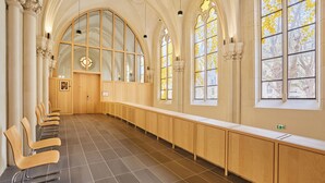 A long, narrow room with wooden benches and a high ceiling. - Hôtel Maison Saint Charles (Paris)