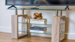 A modern glass-top table with a book titled 'The Fashion Book' and 'Vermeer' on it. - Long stay | 1-Bed Jewellery Quarter Apt | Homely (Birmingham)
