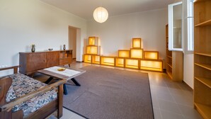 Ein Zimmer mit einer Couch, einem kleinen Tisch, einem Schrank und einer Wand aus beleuchteten Paneelen.