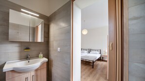 Ein modernes Badezimmer mit einem großen Spiegel, einem Waschbecken und Holzschränken.