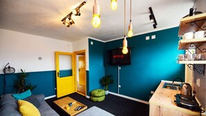 A modern living room with a sofa, coffee table, and a TV mounted on the wall. - Cozy Bright Central APT (Prishtina)