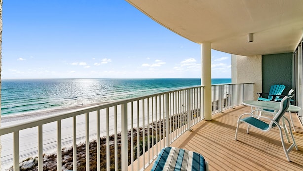 A balcony with a view of the ocean, a table with chairs, and a railing. - Gulf-Front 1BR w/ Beach Service at Long Beach Resort Tower 3 (Panama City Beach)