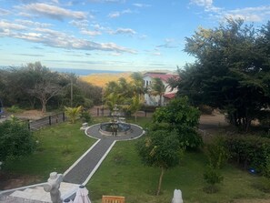 A landscaped garden with a central fountain, a paved walkway, and surrounding greenery. - Spacious family apartment within the Tree Casa resort. Sleeps 8. Pet Friendly. (San Juan del Sur)