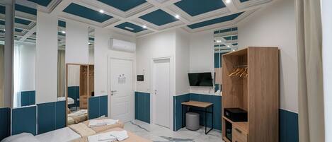 A hotel room with a bed, a desk, a TV, and a wardrobe.