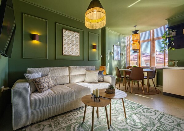 Un salon comprenant un canapé, une table basse et un coin repas avec des chaises et une table.
