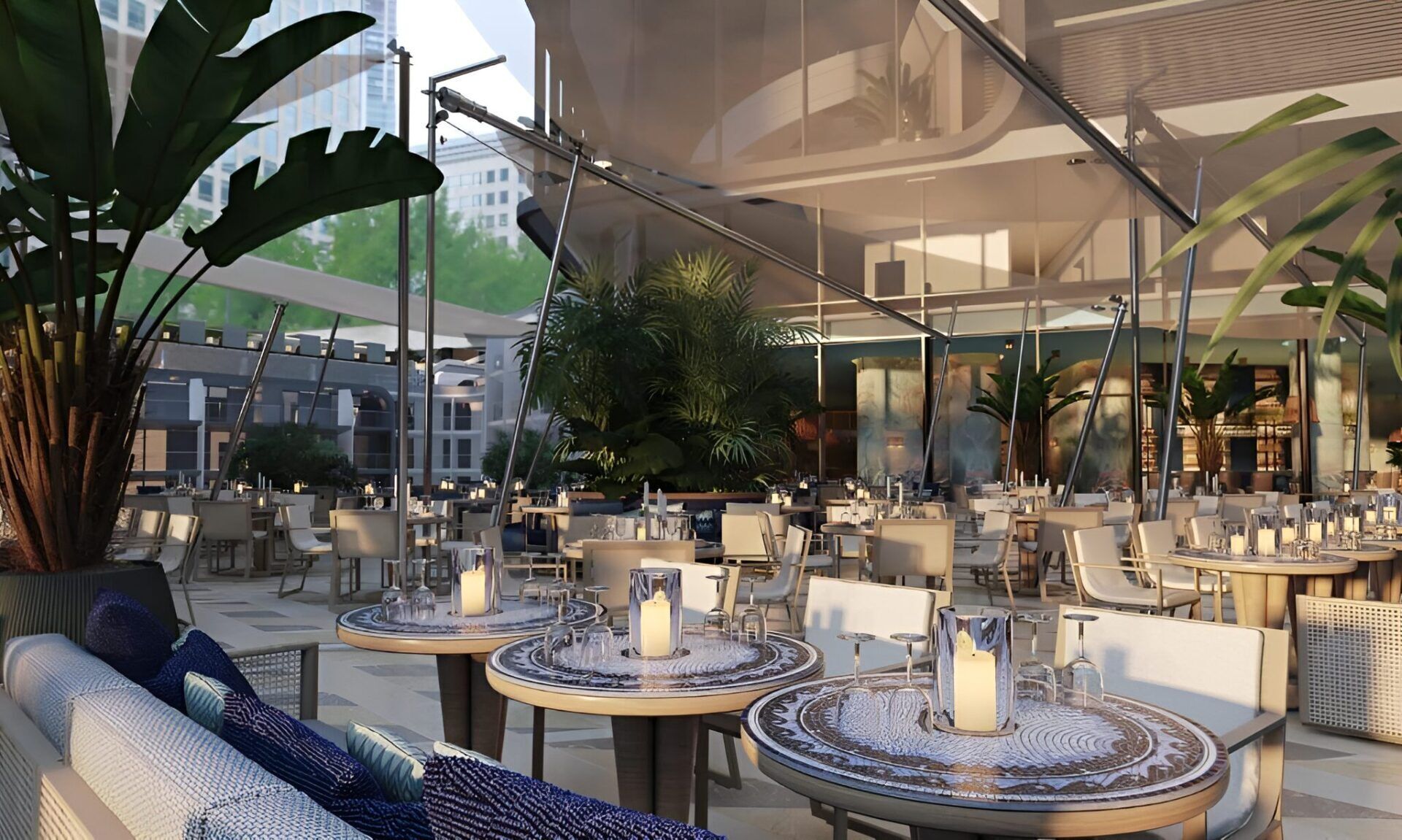 An outdoor dining area with round tables, chairs, and potted plants.