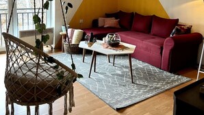 Ein modernes Wohnzimmer mit Hängesessel, Sofa, Couchtisch und einer Pendelleuchte.