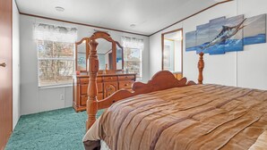 Une chambre à coucher avec un lit à baldaquin, une commode et un grand miroir.