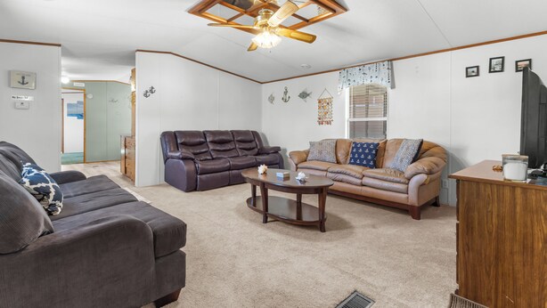 Un salon avec un canapé en cuir marron, un divan beige et une table basse en bois.