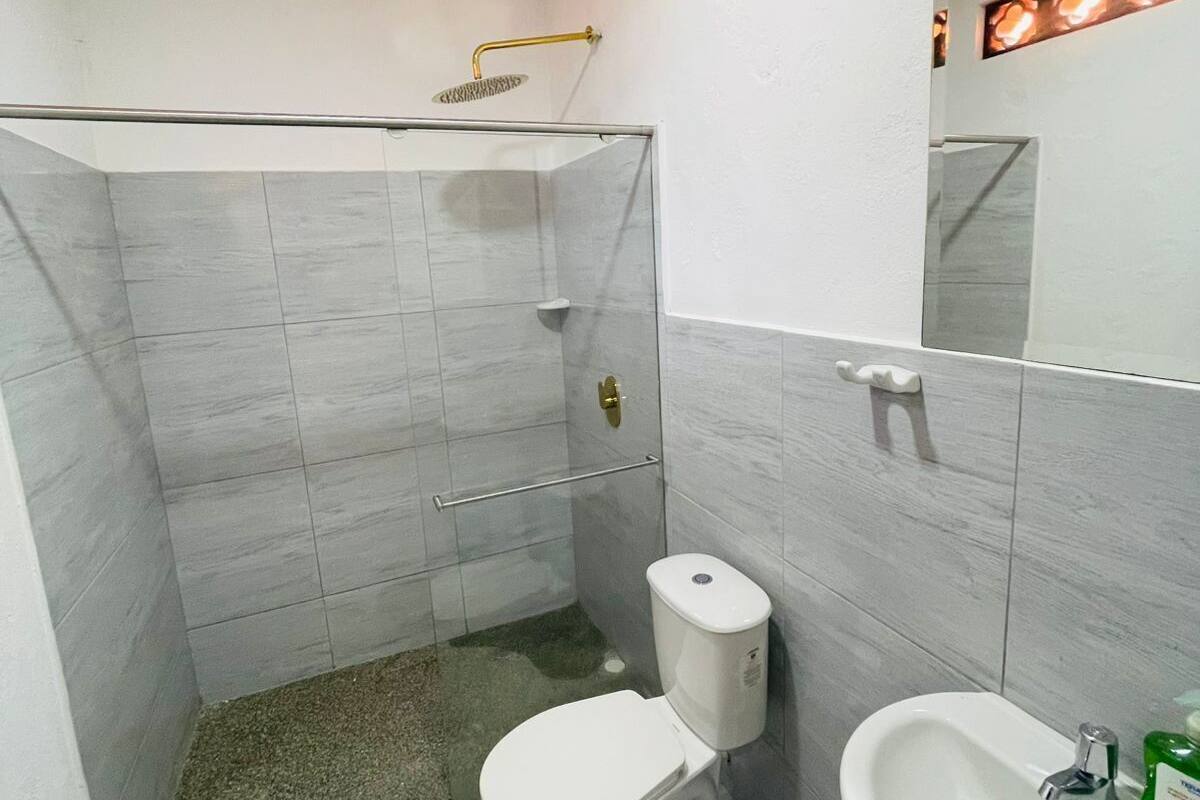 Un baño con ducha, inodoro y lavabo.