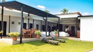 A covered outdoor area with a patio, seating, and potted plants. - HOTEL CAFELIA BOUTIQUE (Pereira)