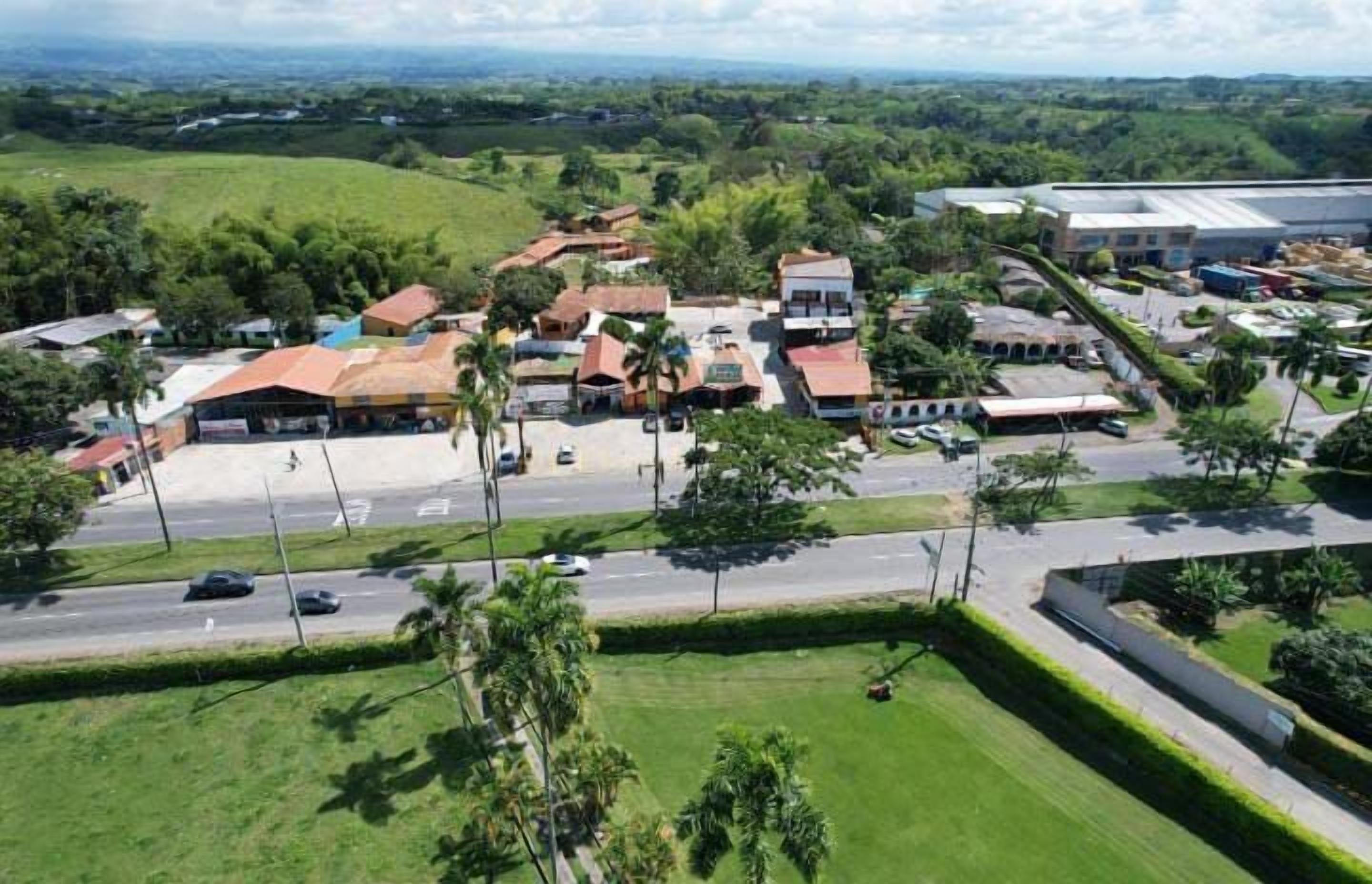 An aerial view of a residential area with houses, a road, and a large industrial building.
