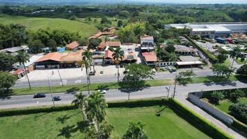 An aerial view of a residential area with houses, a road, and a large industrial building.