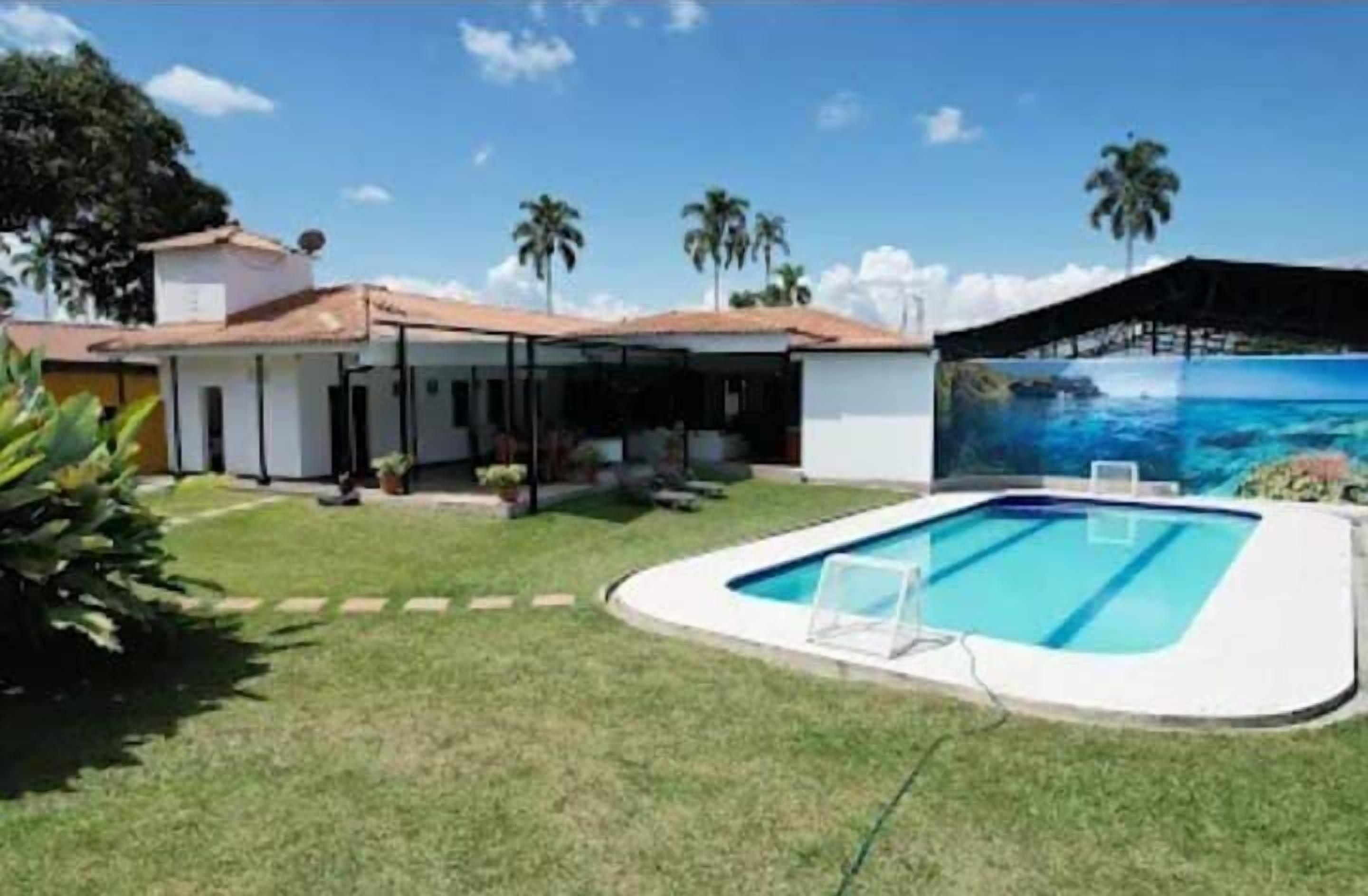 Una casa con piscina, un espacio exterior techado y vistas al océano.