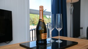 En flaske Canti Prosecco på et sort fad med to tomme vinglas.
