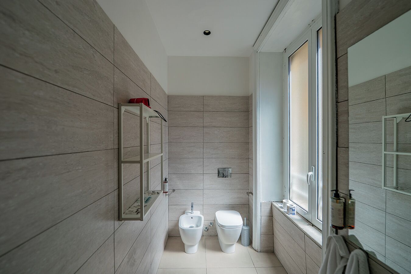 A modern bathroom with a toilet, bidet, and a shower area.