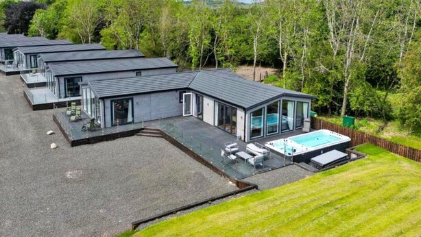 Una casa moderna con piscina, varias habitaciones y un césped bien cuidado.