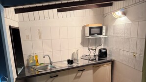 A compact kitchen with a microwave, a coffee maker, and a sink. - Bungalow Korail (Pointe-Noire)