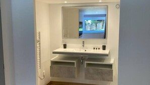 Un baño moderno con lavamanos doble, un espejo grande y vistas al exterior.
