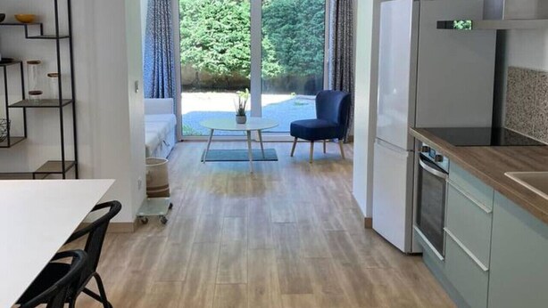 Una cocina moderna con comedor, horno empotrado y vistas al exterior.