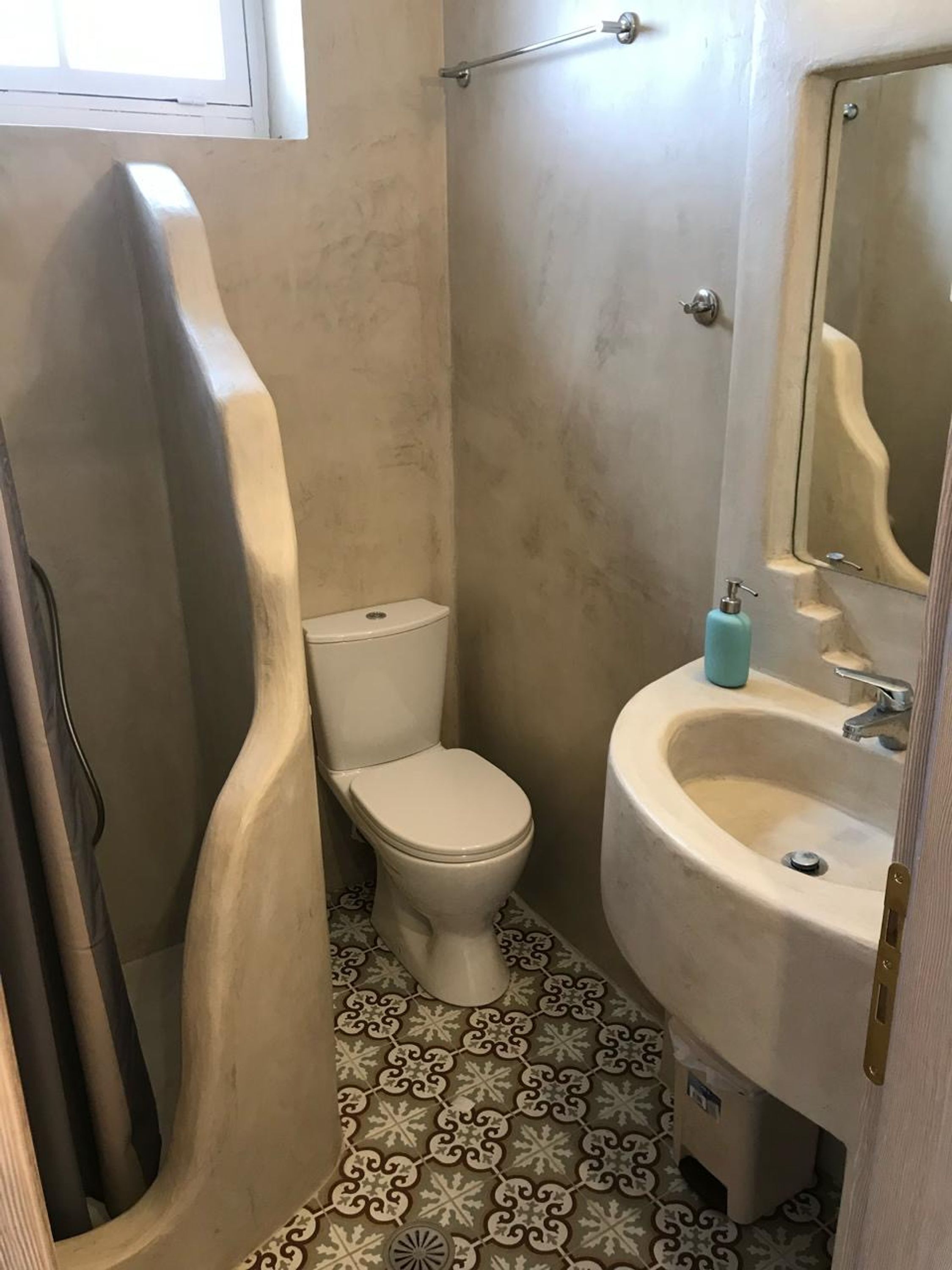 Un baño con inodoro, lavamanos y ducha.