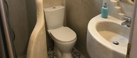 Un baño con inodoro, lavamanos y ducha.
