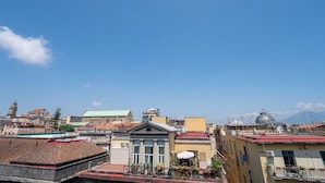 A cityscape with various buildings, including a prominent church with a dome and a bell tower. - GREROS DANTE H. by Clapa Group dislocated hospitality (Naples)