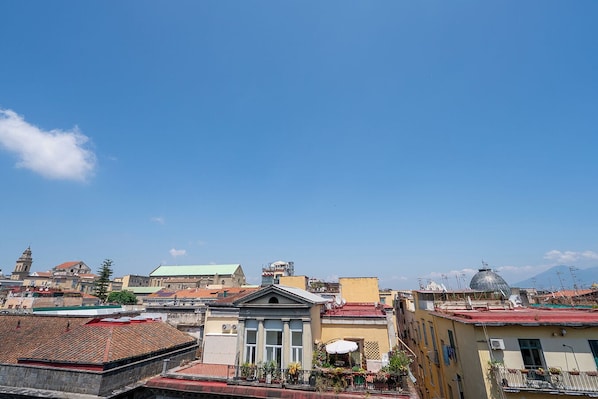 A cityscape with various buildings, including a prominent church with a dome and a bell tower. - GREROS DANTE H. by Clapa Group dislocated hospitality (Naples)