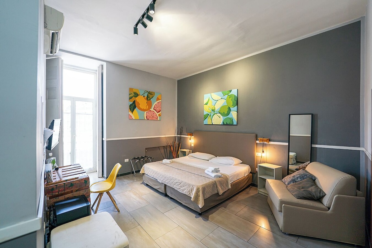 A modern bedroom with a bed, bedside tables, a chair, and artwork on the walls.