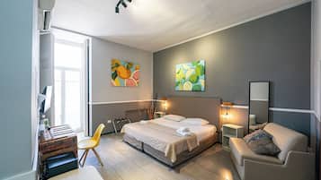 Une chambre à coucher moderne, avec un lit, des tables de chevet, une chaise et des œuvres d’art accrochées aux murs.
