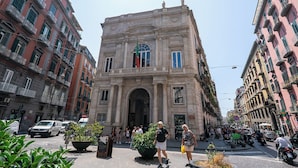 Un bâtiment historique doté d’une entrée imposante, de grandes fenêtres et d’une arche centrale.