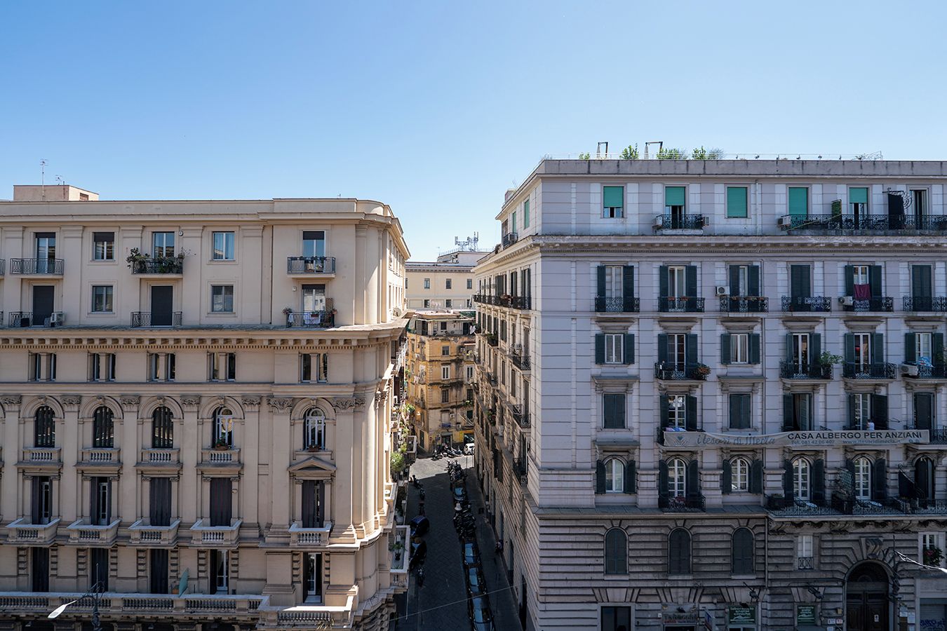 A row of classic European-style buildings with multiple stories, featuring balconies and large windows.