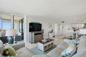 A modern living room with a flat-screen TV, a coffee table, and a sofa. - Waterfront Isla del Sol Condo w Balcony & Pool (St Petersburg)