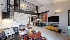 Uma sala de estar moderna com escada, área de jantar e cozinha.