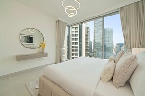 A modern bedroom with a large bed, a round mirror, a view of tall buildings, and a cityscape. - Luxury 1BR LIV Marina Modern with Marina View (Dubai)
