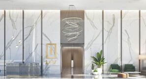 A modern lobby with a marble wall, a spiral light fixture, and a reception desk. - Luxury 1BR LIV Marina Modern with Marina View (Dubai)