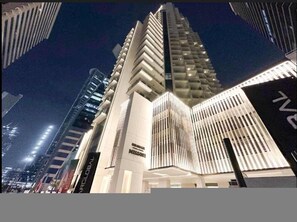 Ein modernes Hochhaus mit einem markanten Fassadendesign, das vertikale Lamellen und Balkone aufweist.