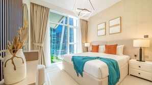 Habitación de hotel moderna con una cama grande, lámparas de noche, un escritorio y vistas a la ciudad.