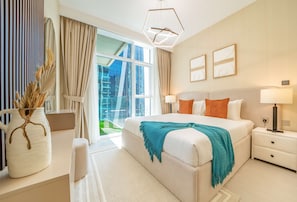 Ein modernes Hotelzimmer mit einem großen Bett, Nachttischlampen, einem Schreibtisch und Blick auf die Stadt.