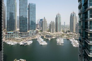 A marina with numerous boats docked, surrounded by high-rise buildings with modern architecture. - Experience 2BR Luxury Living at in LIV Marina (Dubai)