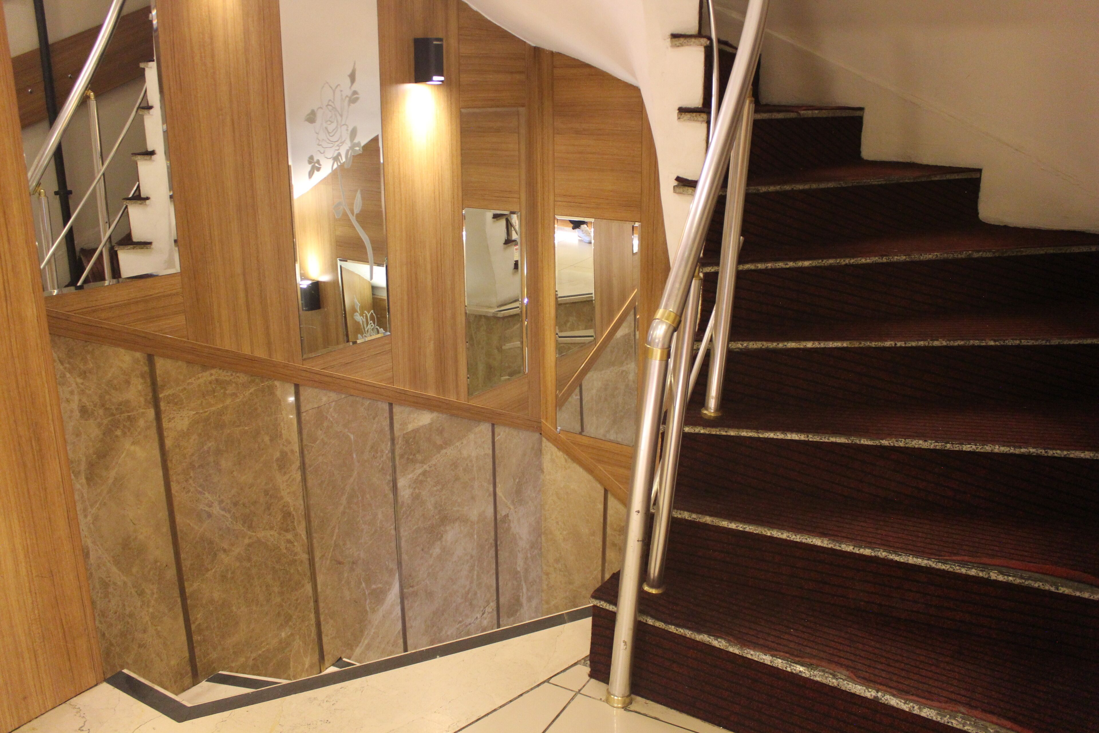 A staircase with wooden railings and a marble wall.