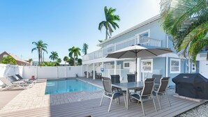 Zona junto a la piscina con piscina, mobiliario exterior y una parrilla.