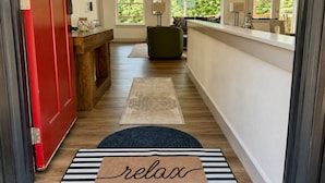 A hallway with a red door, a bench, a reception desk, and a rug with 'relax' written on it. - 25% late summer discount!  9BR Theater Room Dock Slip in cove, Sleeps 30! (Lafollette)
