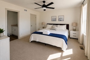 A bedroom with a bed, bedside tables, a ceiling fan, and artwork on the wall. - 9BR Theater Room Retreat: Dock Slip in cove, Sleeps 30! EV charger! (Lafollette)