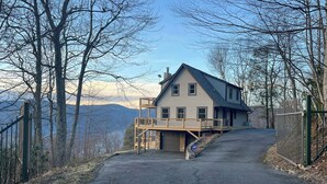 Ein zweistöckiges Haus mit Balkon, Garage und Auffahrt zu einem verschlossenen Eingang.