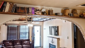 A cozy living room with a leather sofa, a fireplace, and a bookshelf with books and decorative items. - Historic Family Escape Near Downtown, Romantic + Pet-Friendly (Wilmington)